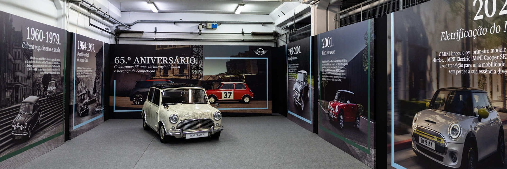 Um MINI Clássico e um MINI Cooper E lado a lado debaixo de árvores.